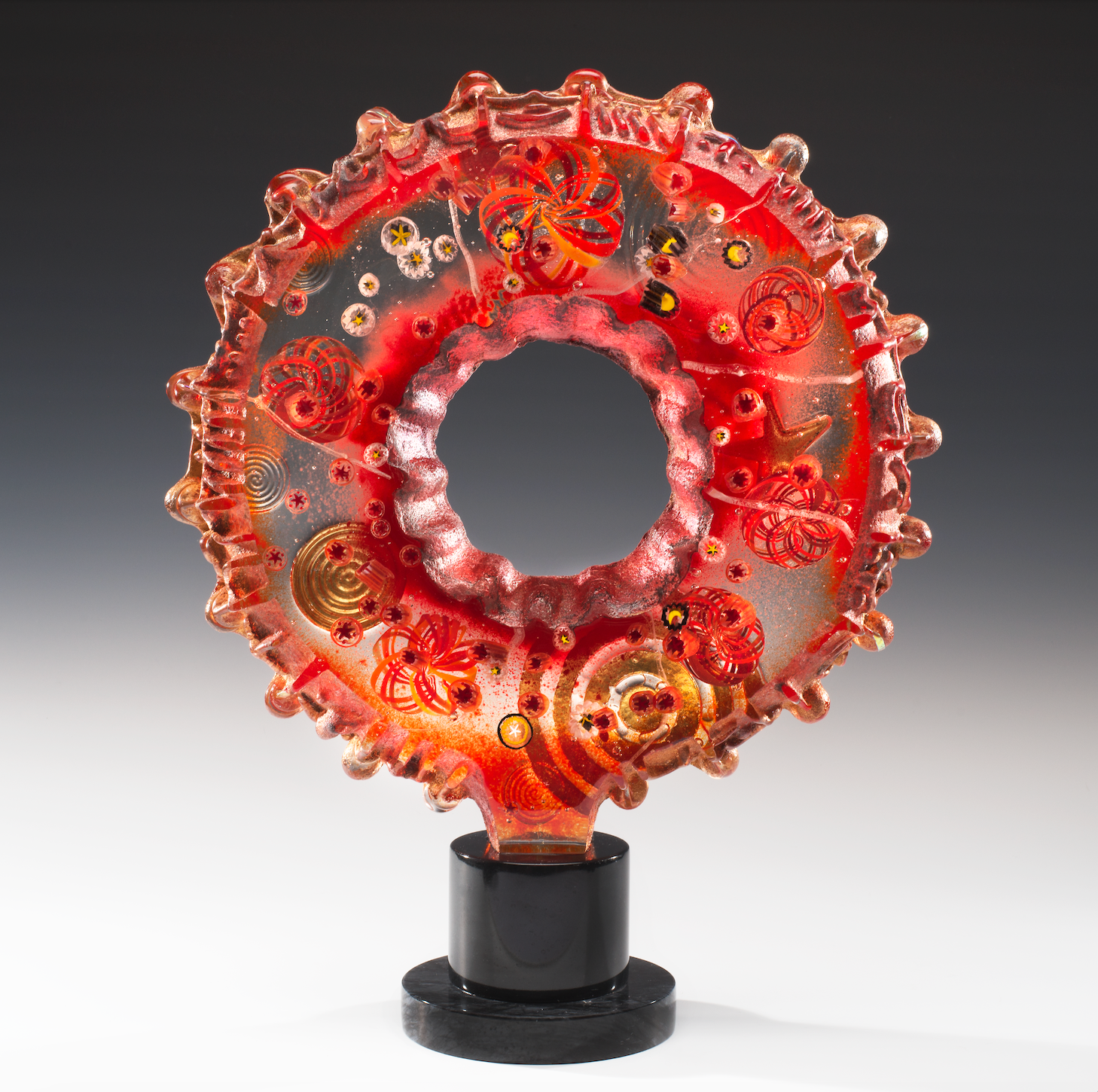 A red glass sculpture with a hole in the middle