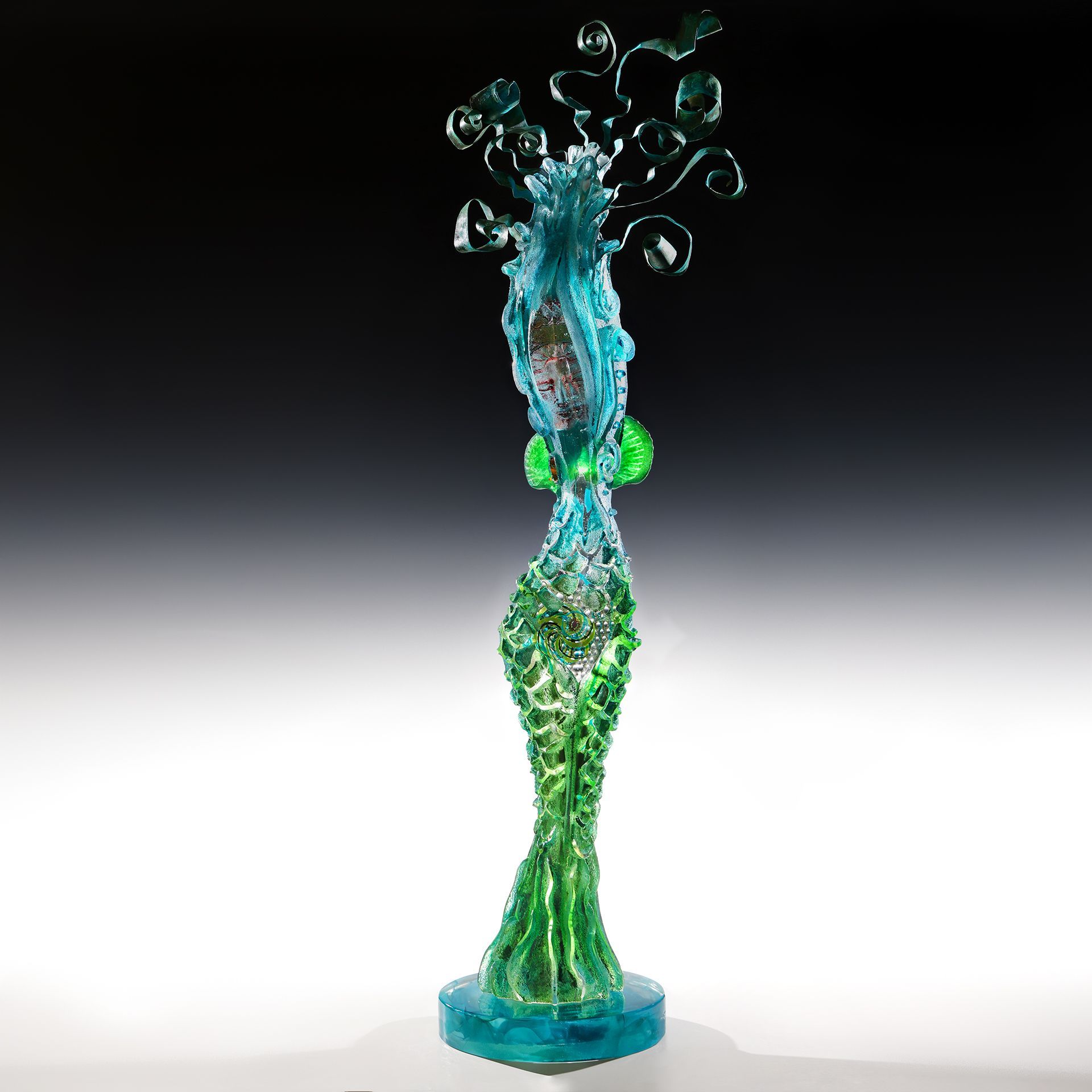 A green and blue statue of a woman with bubbles coming out of her head