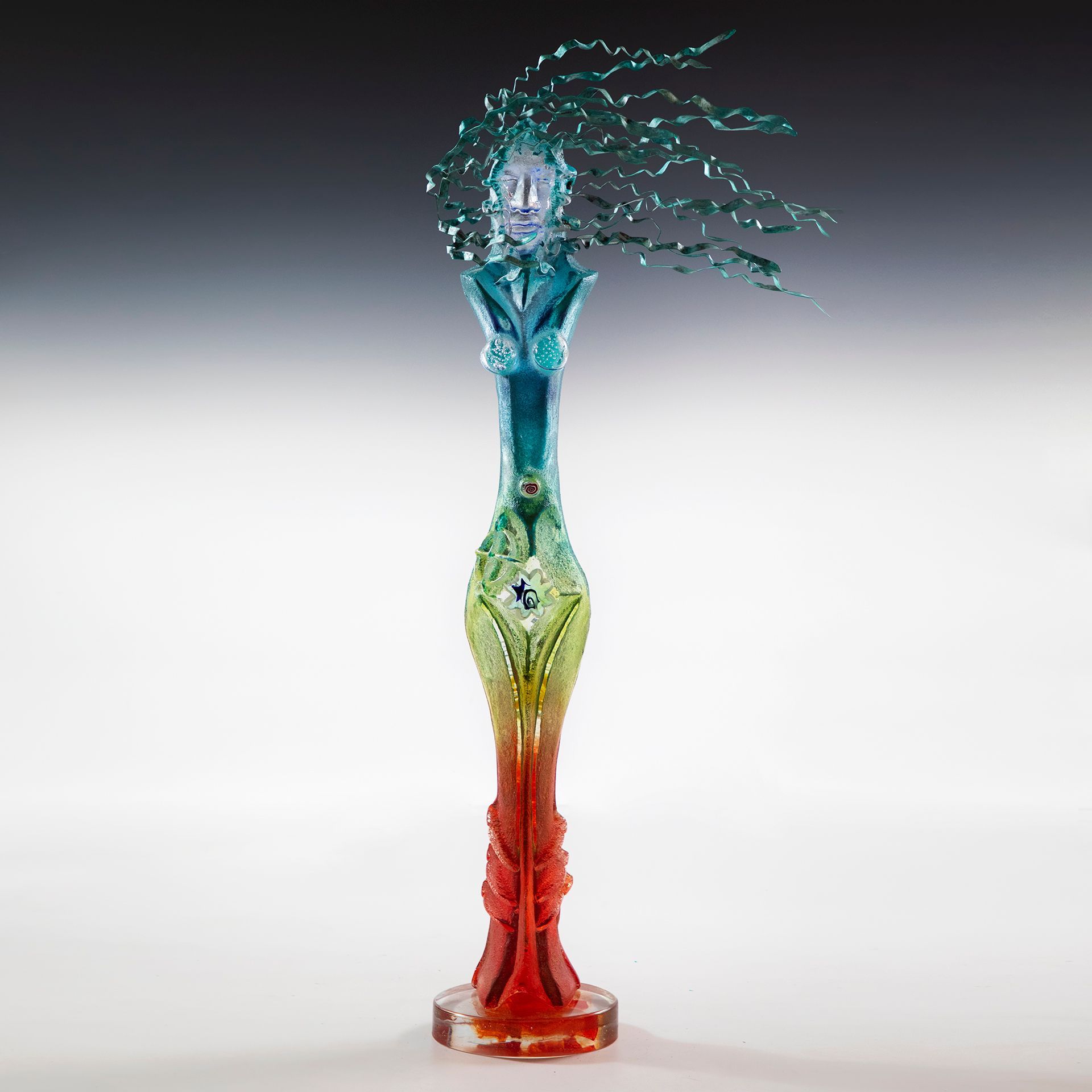 A rainbow colored vase with a face on top of it