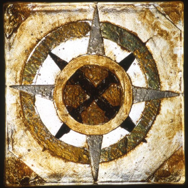 A square tile with a compass on it