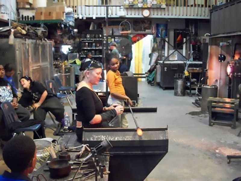 A group of people are working in a glass factory