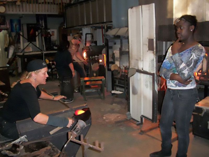 A group of people are working in a glass factory