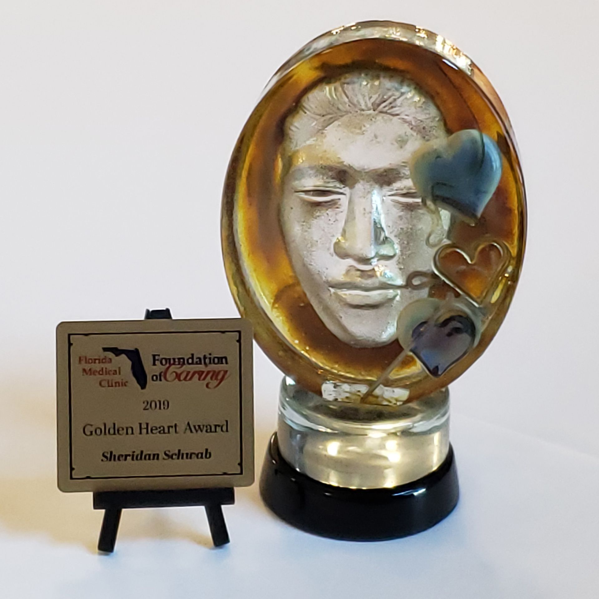 A foundation of caring award with a face and hearts on it
