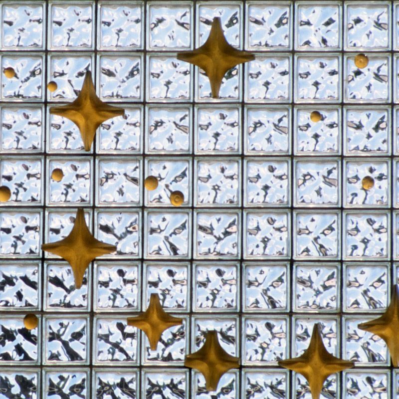 A wall of glass blocks with gold stars on them