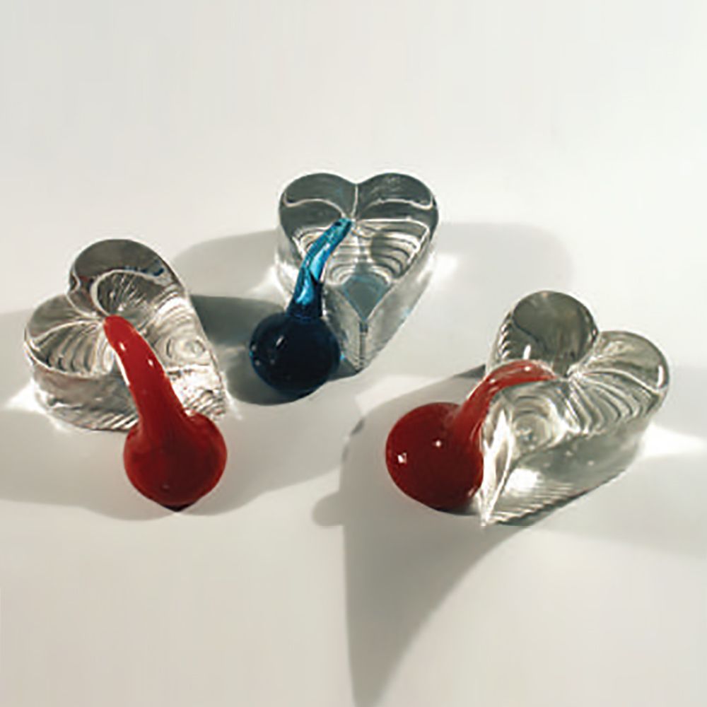 Three heart shaped glass objects with a red one in the middle