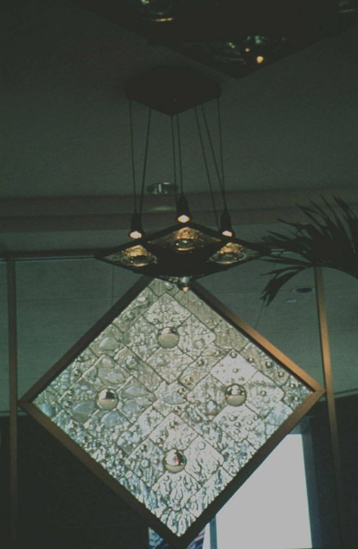 A diamond shaped light fixture hanging from the ceiling