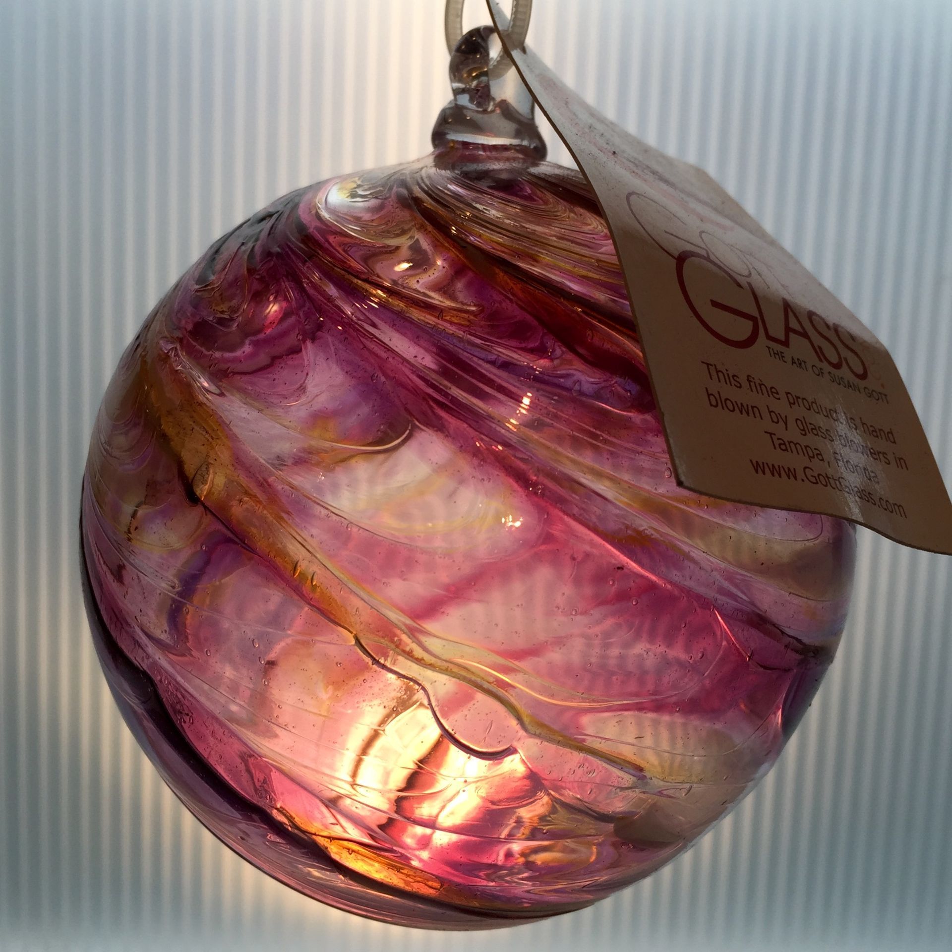 A purple glass ball with a tag that says glass