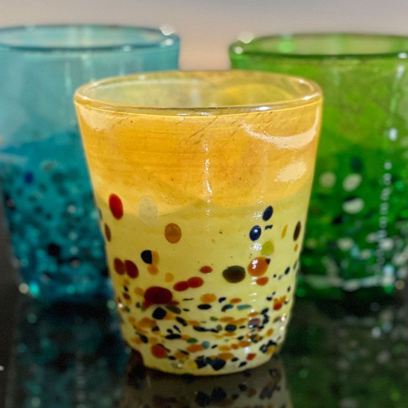Three different colored glasses are sitting on a table.