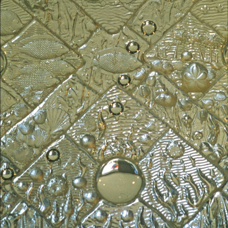 A close up of a shiny metal surface with bubbles on it