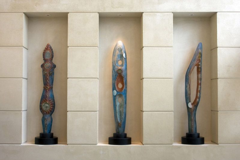 Four sculptures are displayed in a niche on a wall