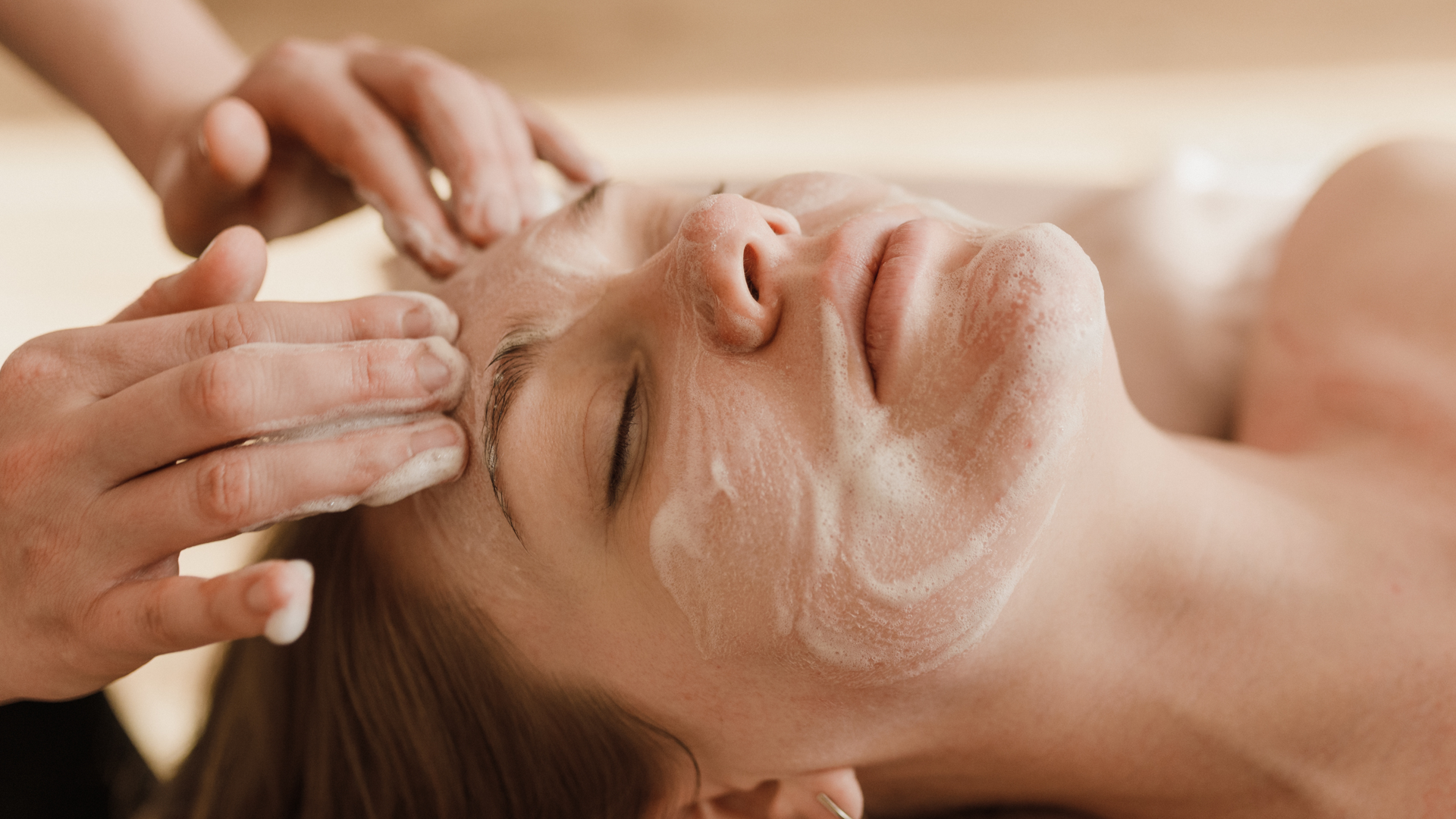 A woman is getting a facial treatment at a spa.