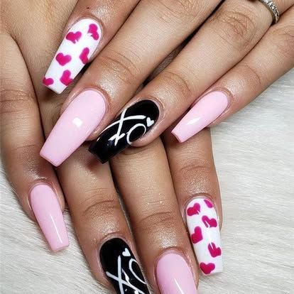 A close up of a woman 's nails with hearts on them.