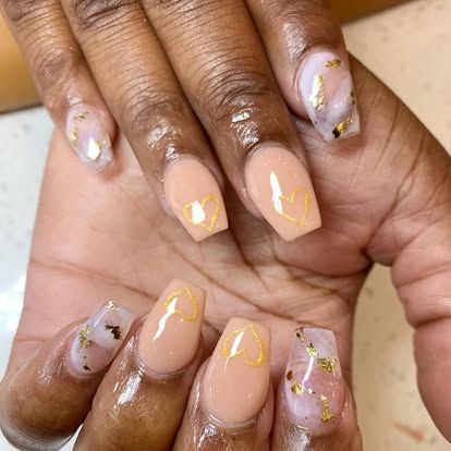A close up of a woman 's nails with a heart on them.