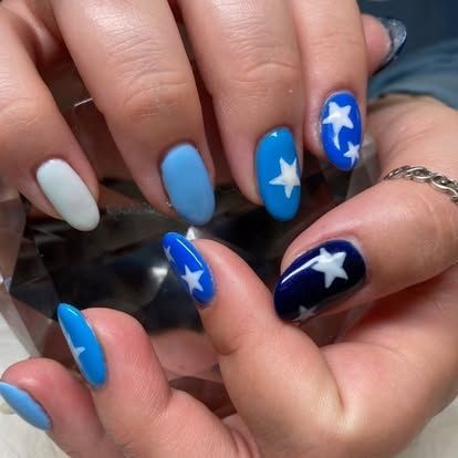 A close up of a woman 's nails with blue and white stars