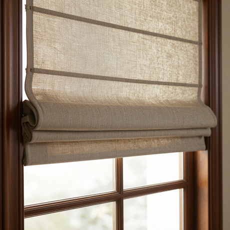Beige woven window shade partially lowered over a sunlit wooden window frame