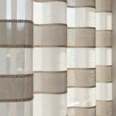 Close-up of beige and taupe striped sheer curtains hanging in front of a window