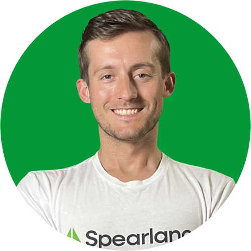 Smiling man in a white Spearland T-shirt against a bright green background