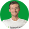 Smiling man in a white Spearland T-shirt against a bright green background