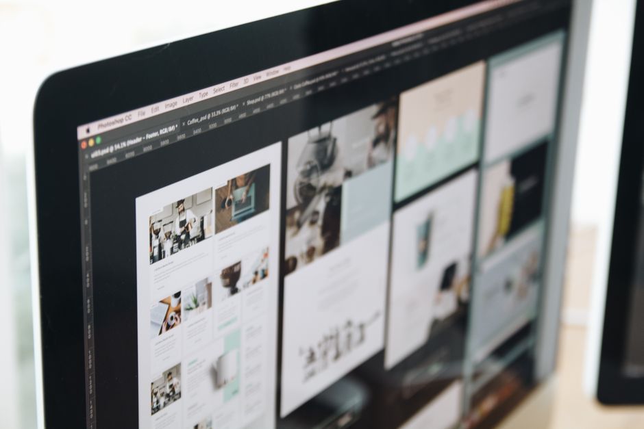 Close-up of a desktop monitor showing a website layout with multiple tiled images and panels