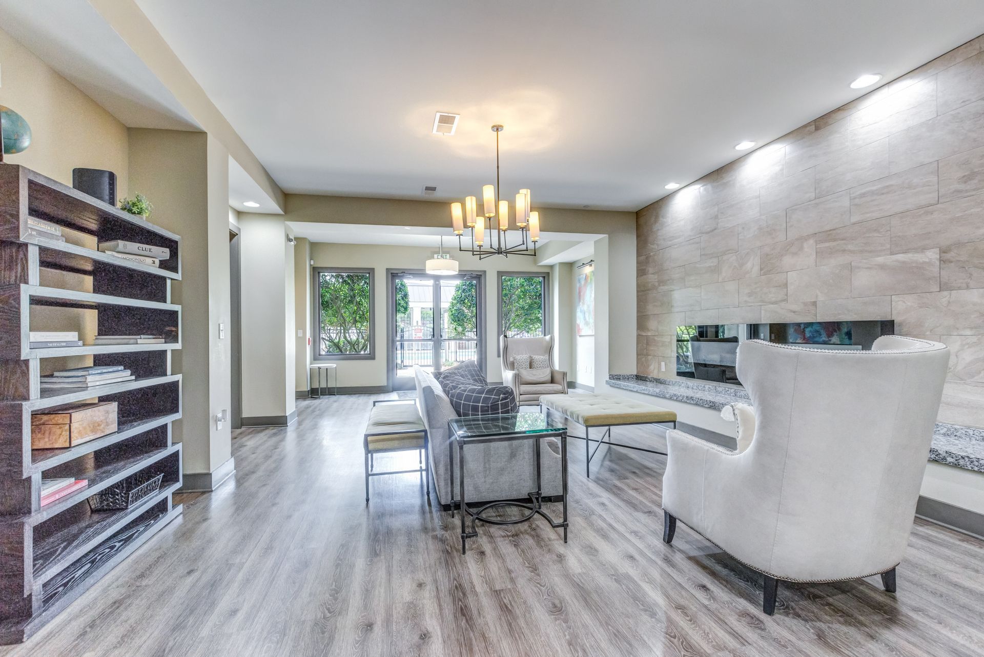 Living room with gray wood floors, a fireplace, and large windows at Town Center at Lake Carolina in Columbia, SC.
