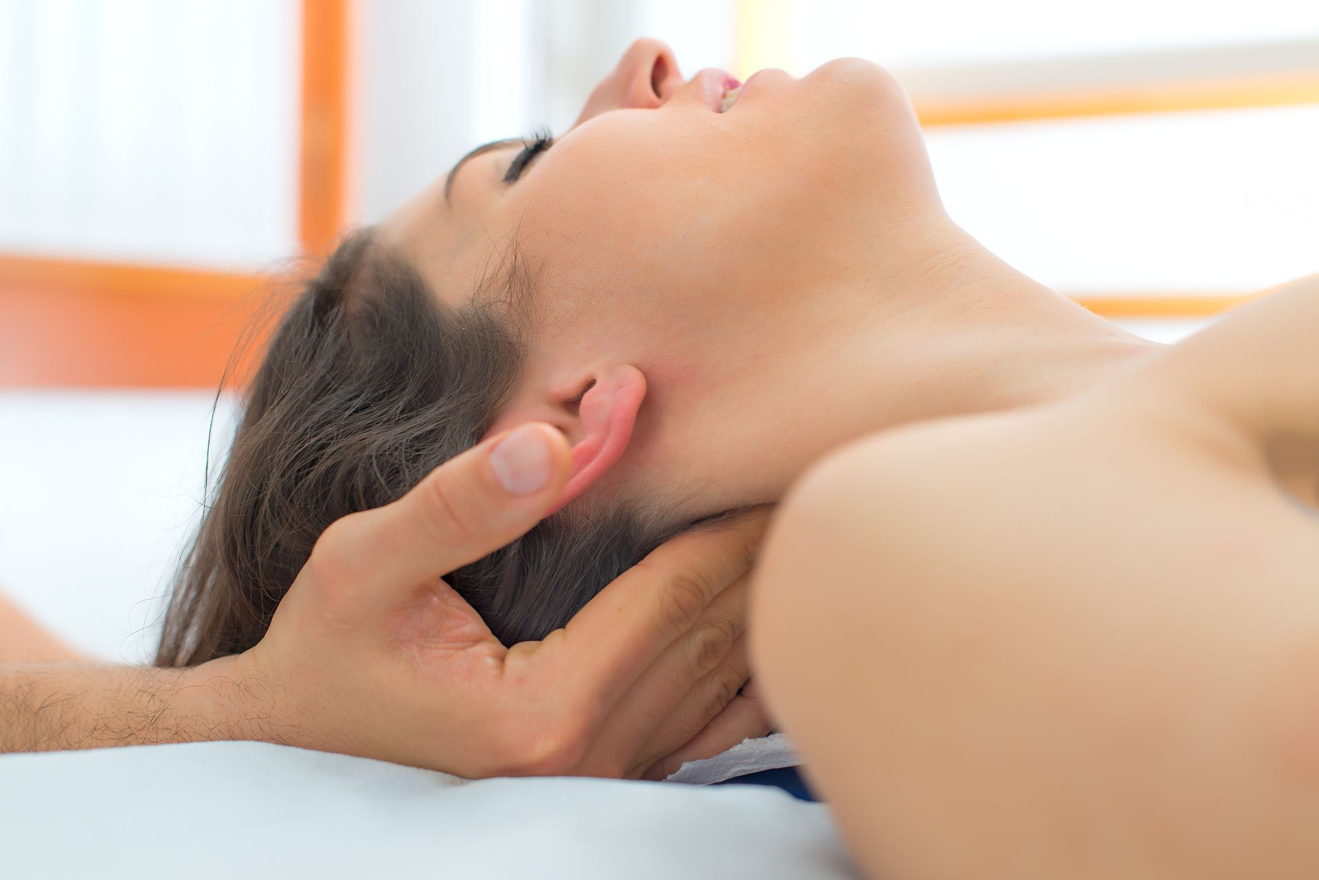 Therapist massaging the neck of woman In the studio.