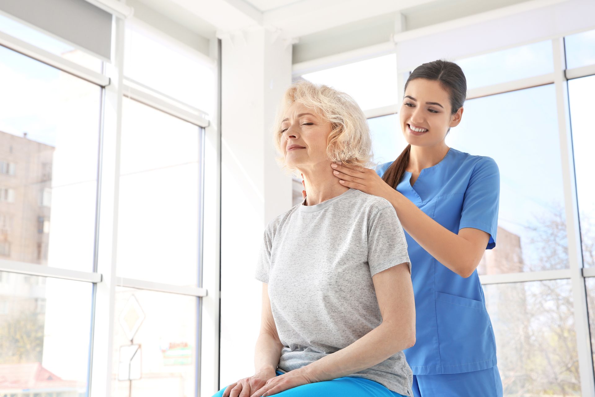 Physiotherapist working with elderly patient in clinic.