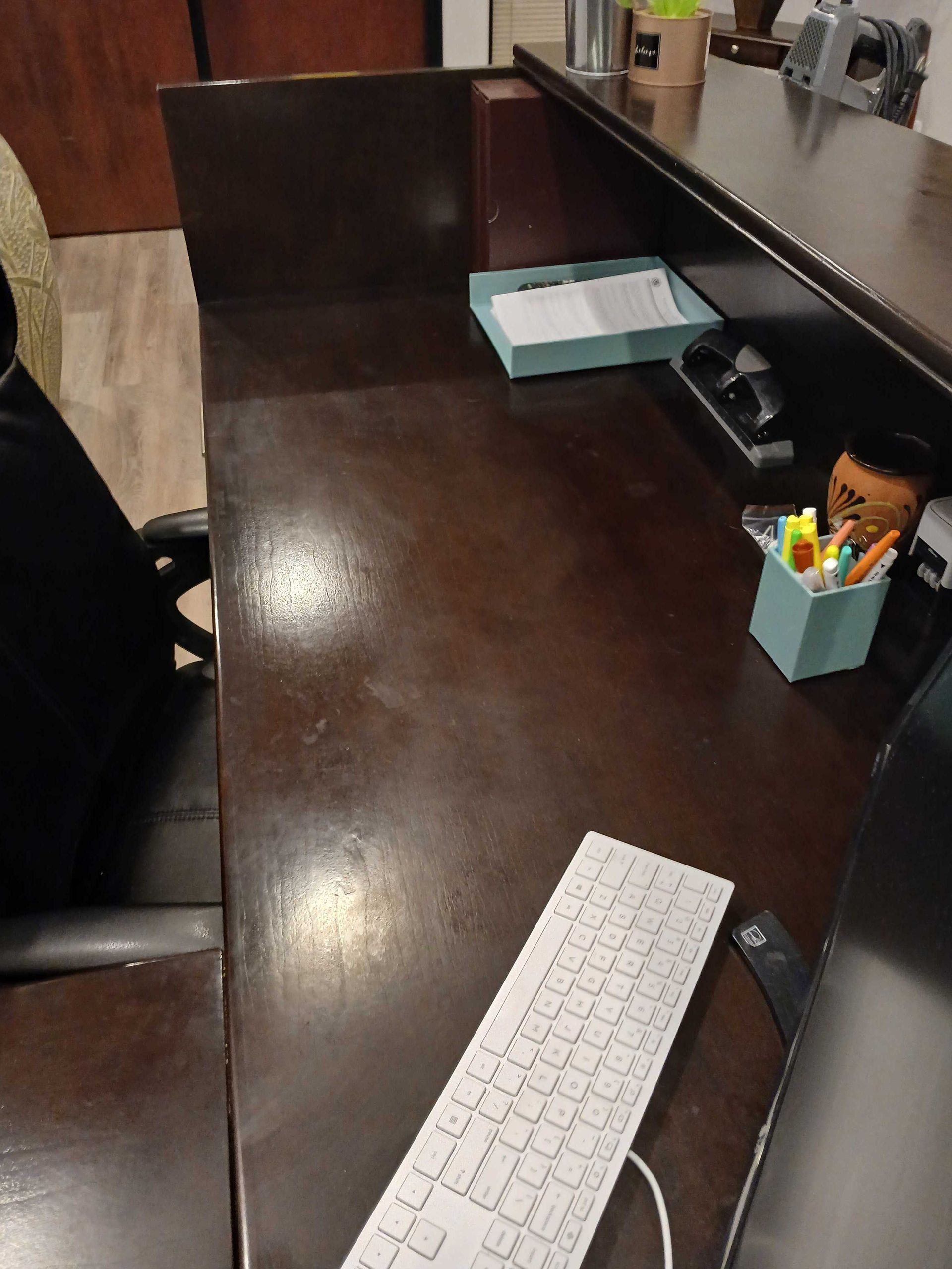 A desk with a keyboard and a pen holder