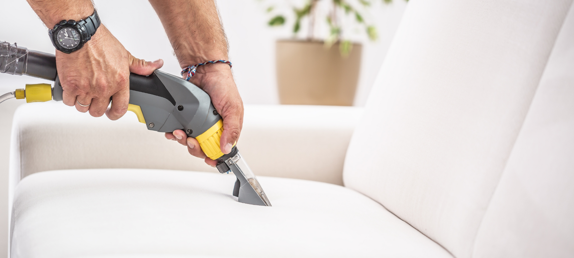 Using a vacuum tool for upholstery cleaning in an Airbnb vacation rental.
