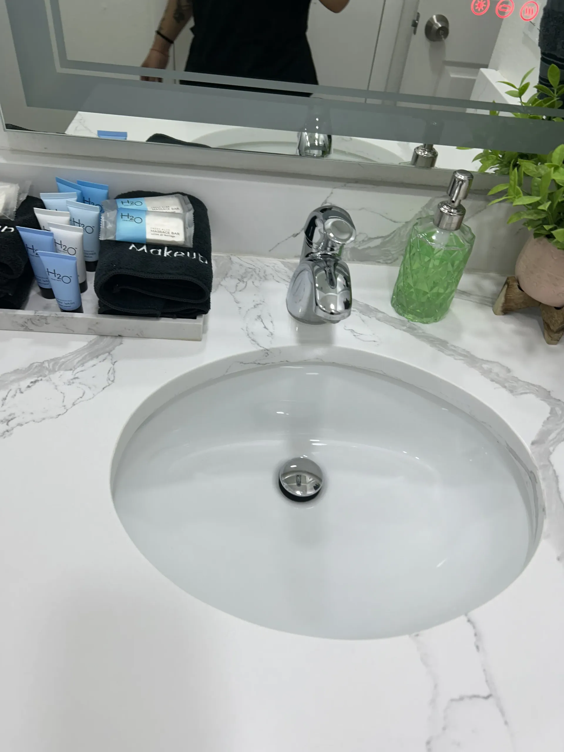 A shiny, deep-cleaned sink with neatly arranged toiletries.
