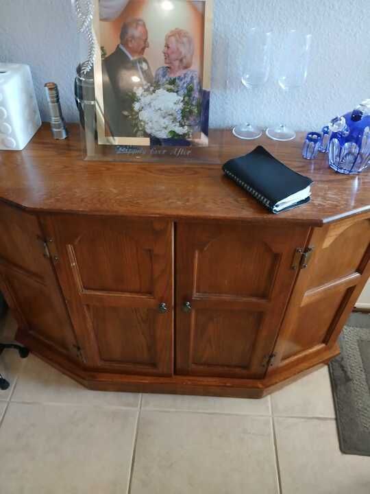 A wooden cabinet with a picture of a bride and groom on top of it.