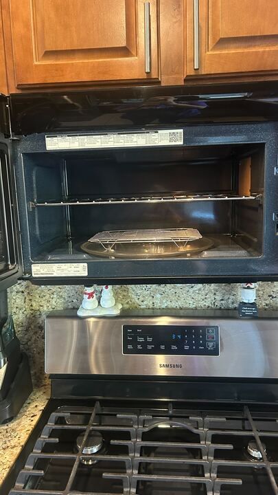 A microwave oven is sitting on top of a stove in a kitchen.