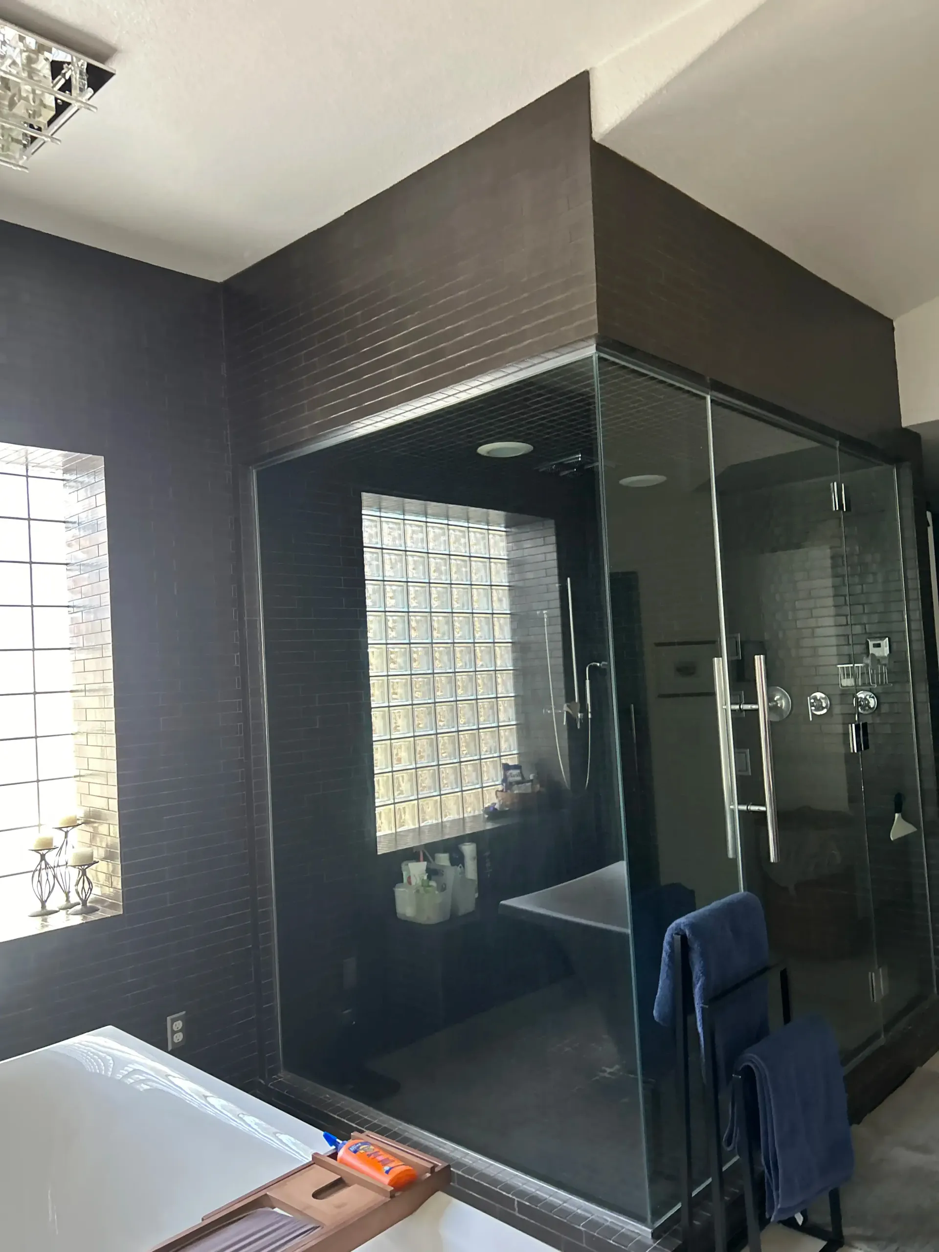 A bathroom with a glass shower door and a bathtub.