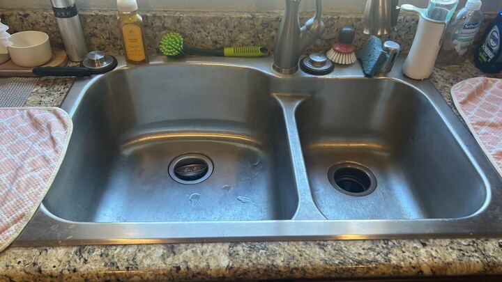 A kitchen with a stove , sink , and utensils on the counter.