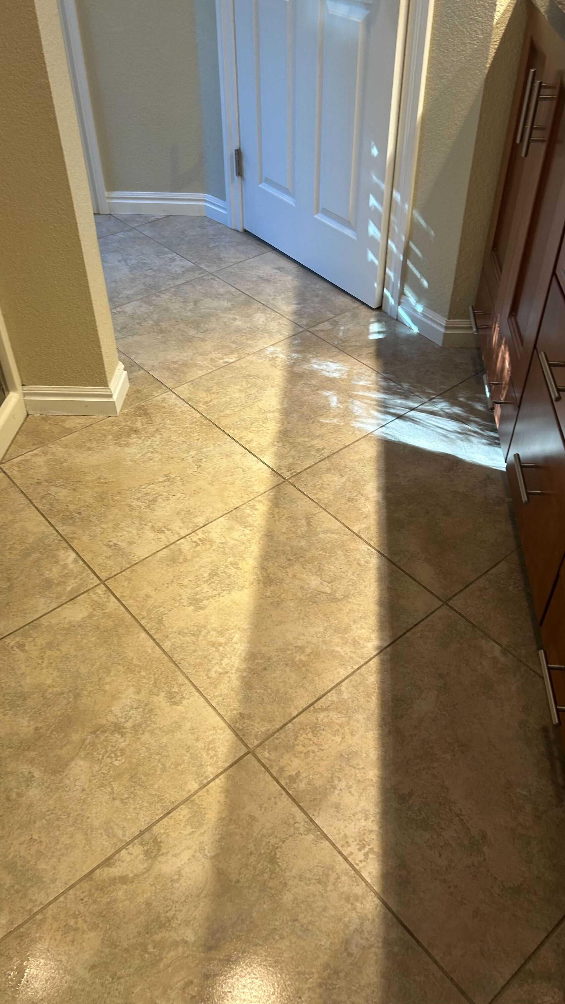 A hallway with tile floors and a door.