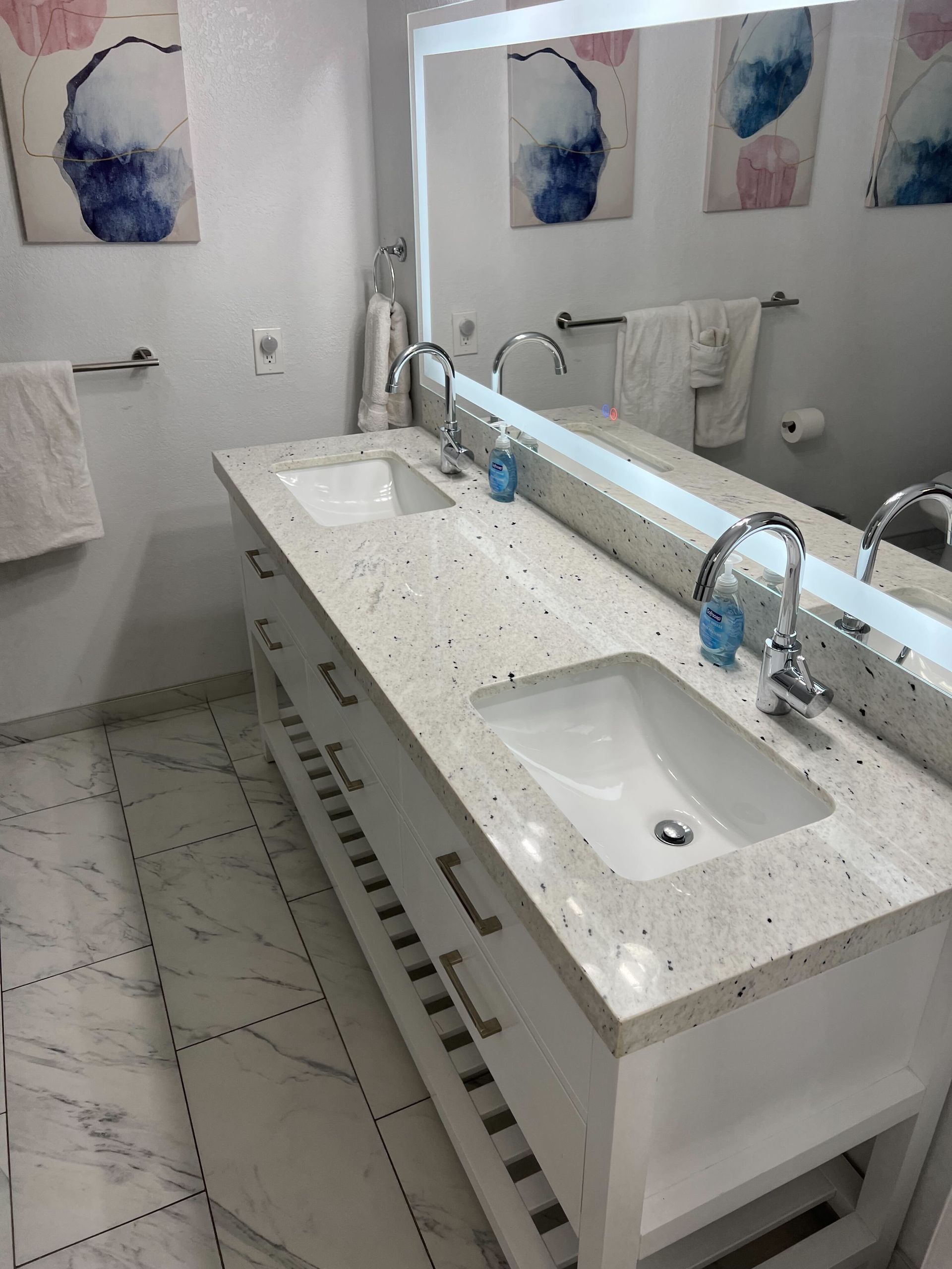 A bathroom with two sinks and a large mirror