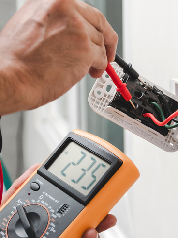Iemand gebruikt een multimeter om een stopcontact te testen