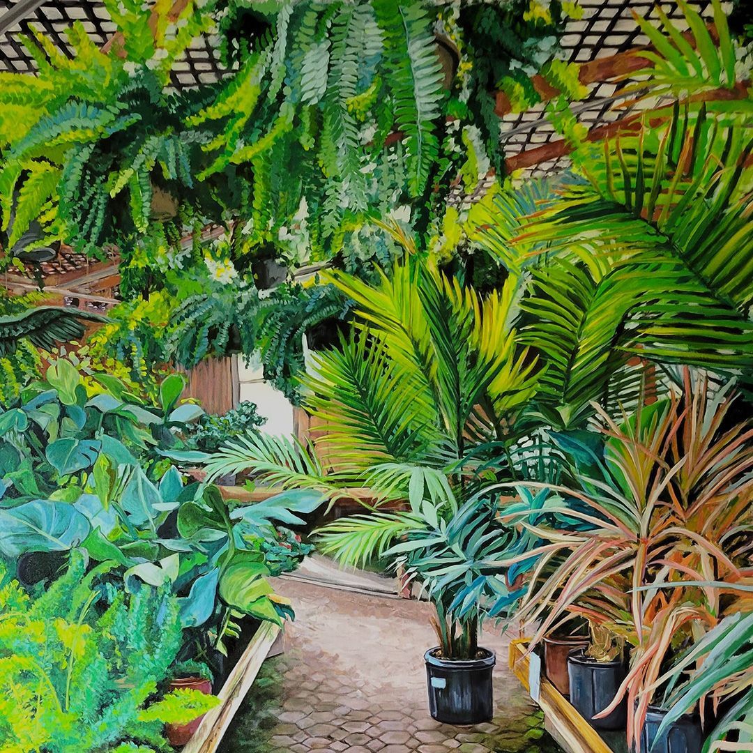Dense tropical nursery aisle with lush green potted plants and ferns lining a narrow path