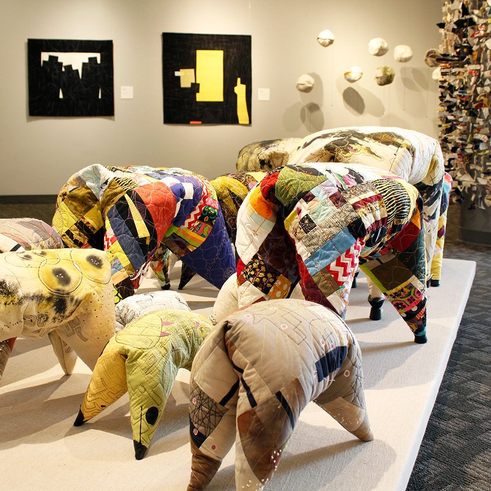 Colorful patchwork animal sculptures displayed in a gallery-like exhibition space.