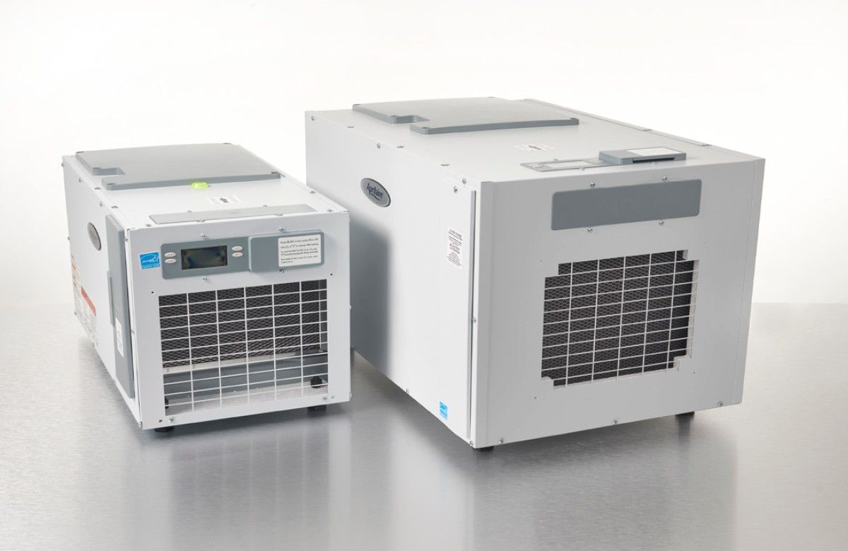 Two white industrial units with vented fronts and control panels, shown side by side on a metal surface.