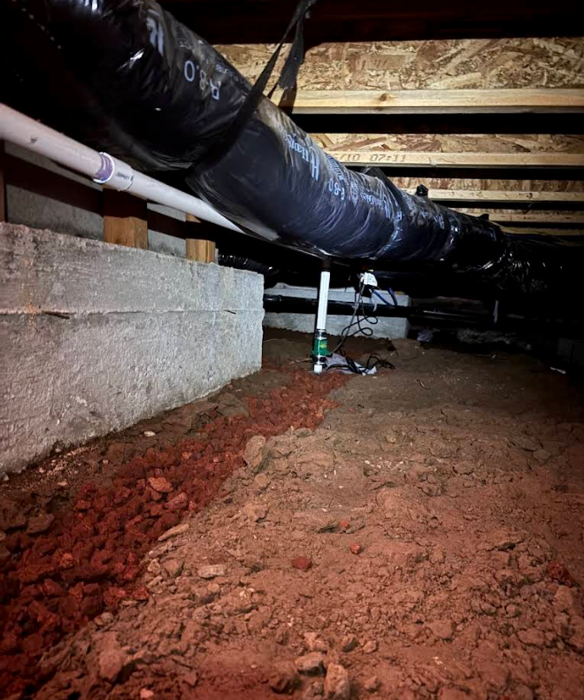 Crawl space with exposed black ductwork, wooden joists, and dirt floor under a house