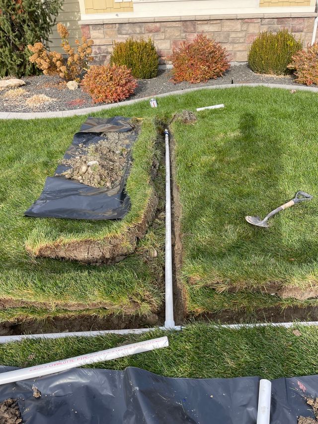 Front yard lawn repair with sod seams, black landscape fabric, and mulch along a house foundation