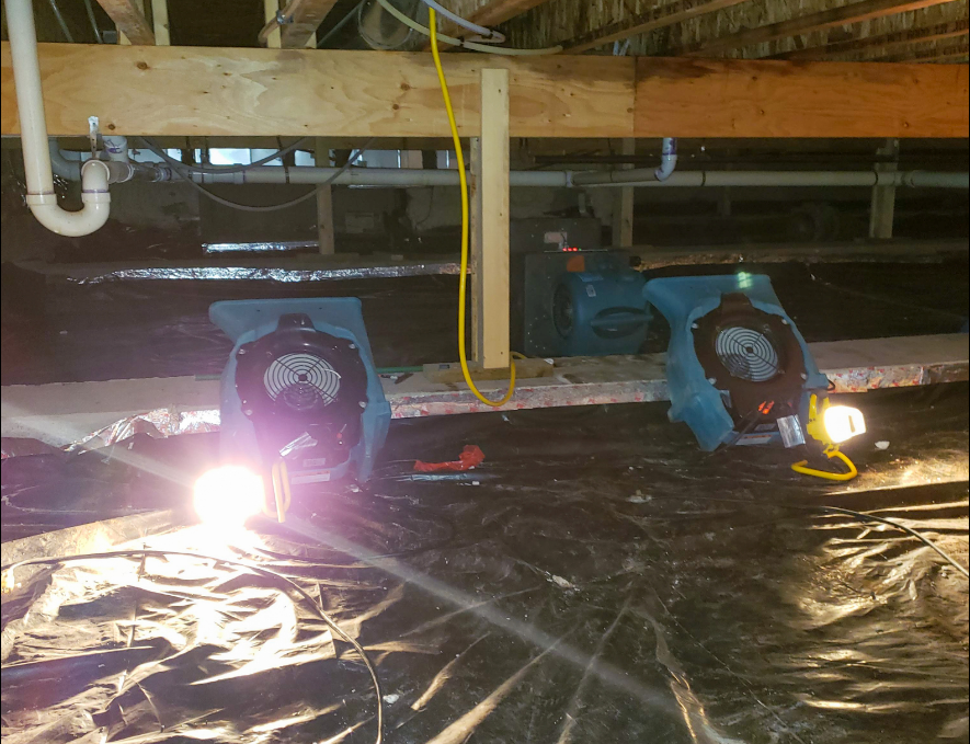 Two blue fans on a plastic-covered floor under a wooden beam, with bright sparks