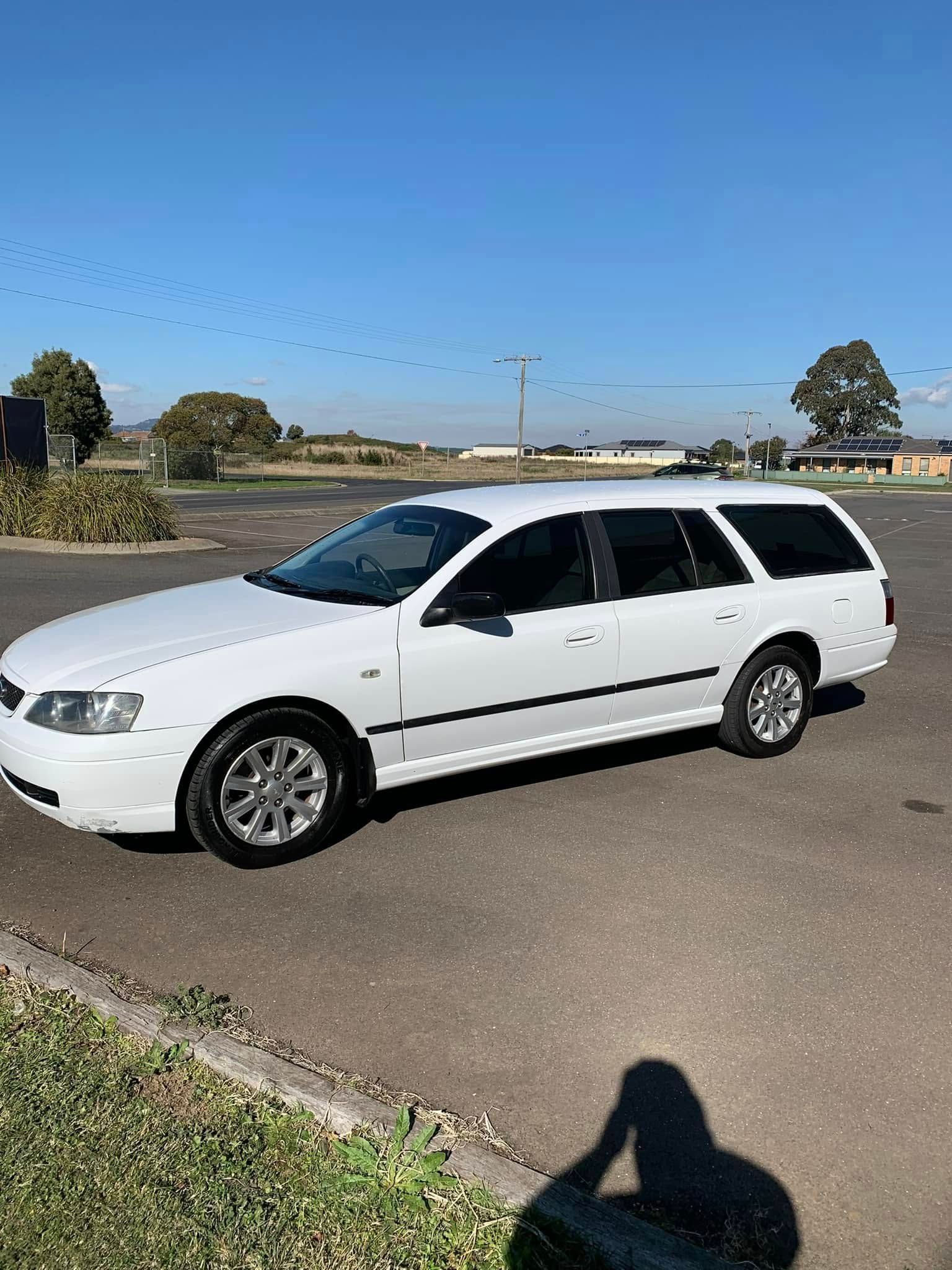 A white station wagon is parked in a parking lot.