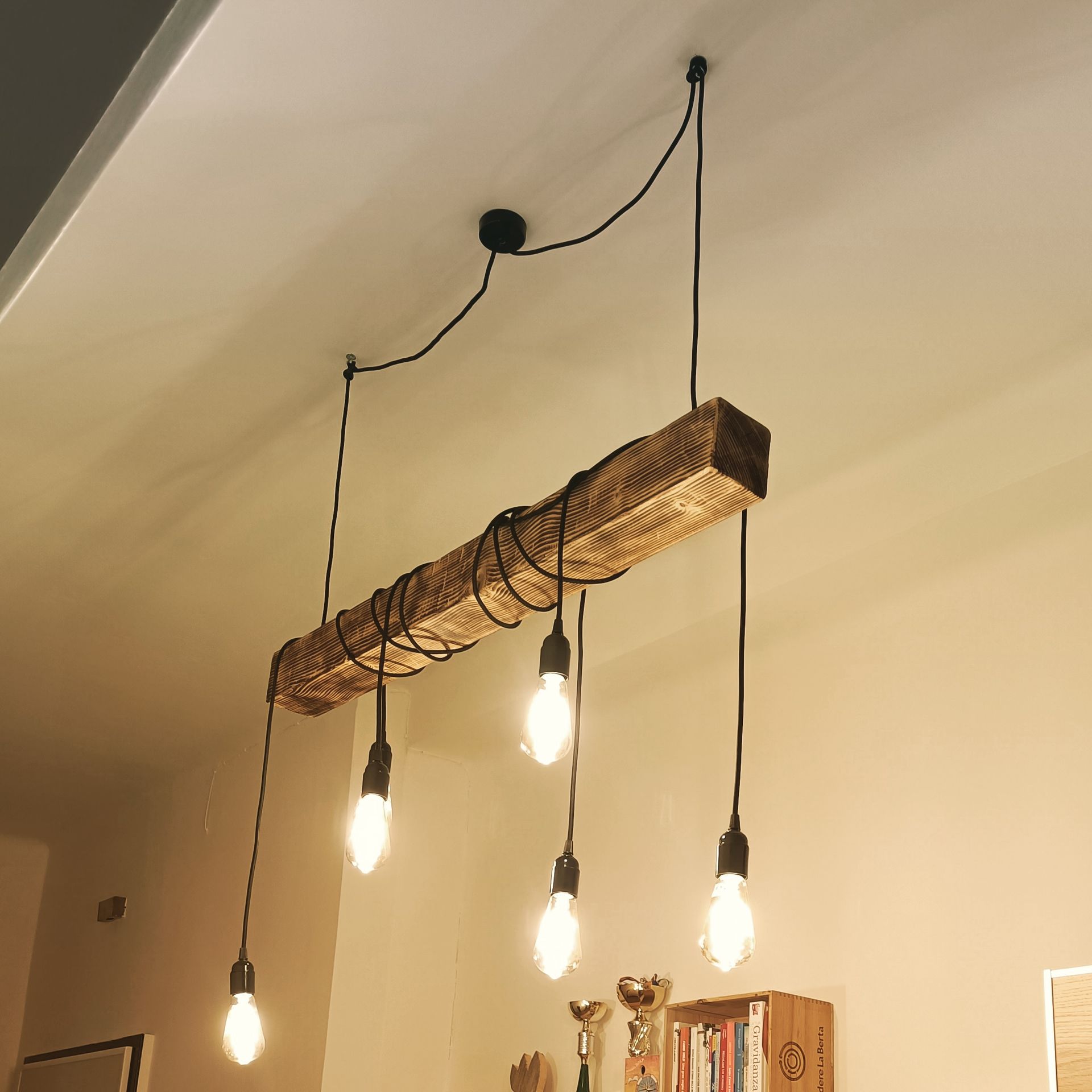 Lampadario rustico con travi in ​​legno e lampadine Edison appese al soffitto.