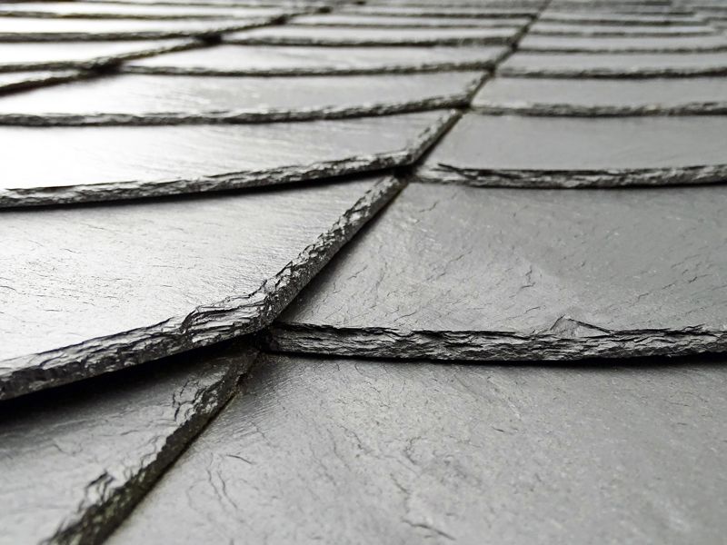 Close-up of overlapping gray slate roof tiles with textured surfaces