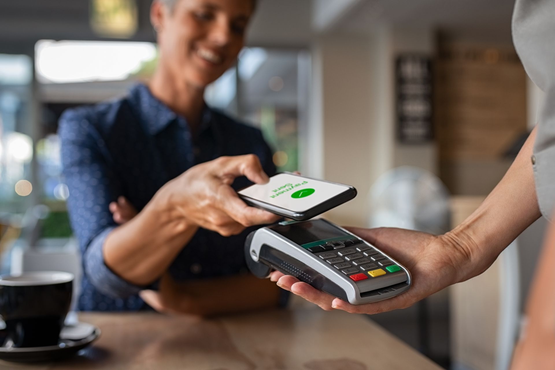 a woman is using a smart phone to pay for something