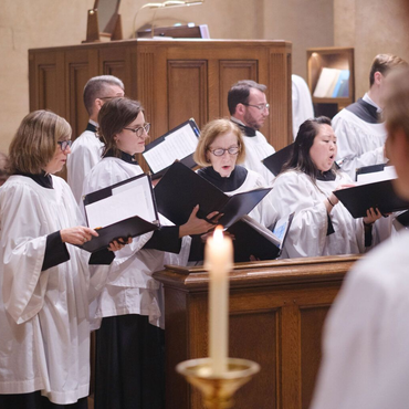 A religious procession with altar servers carrying candles and incense at an altar, in church.