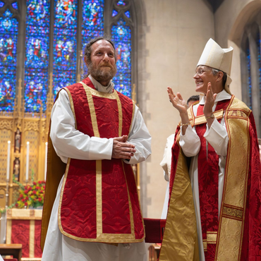 A religious procession with altar servers carrying candles and incense at an altar, in church.