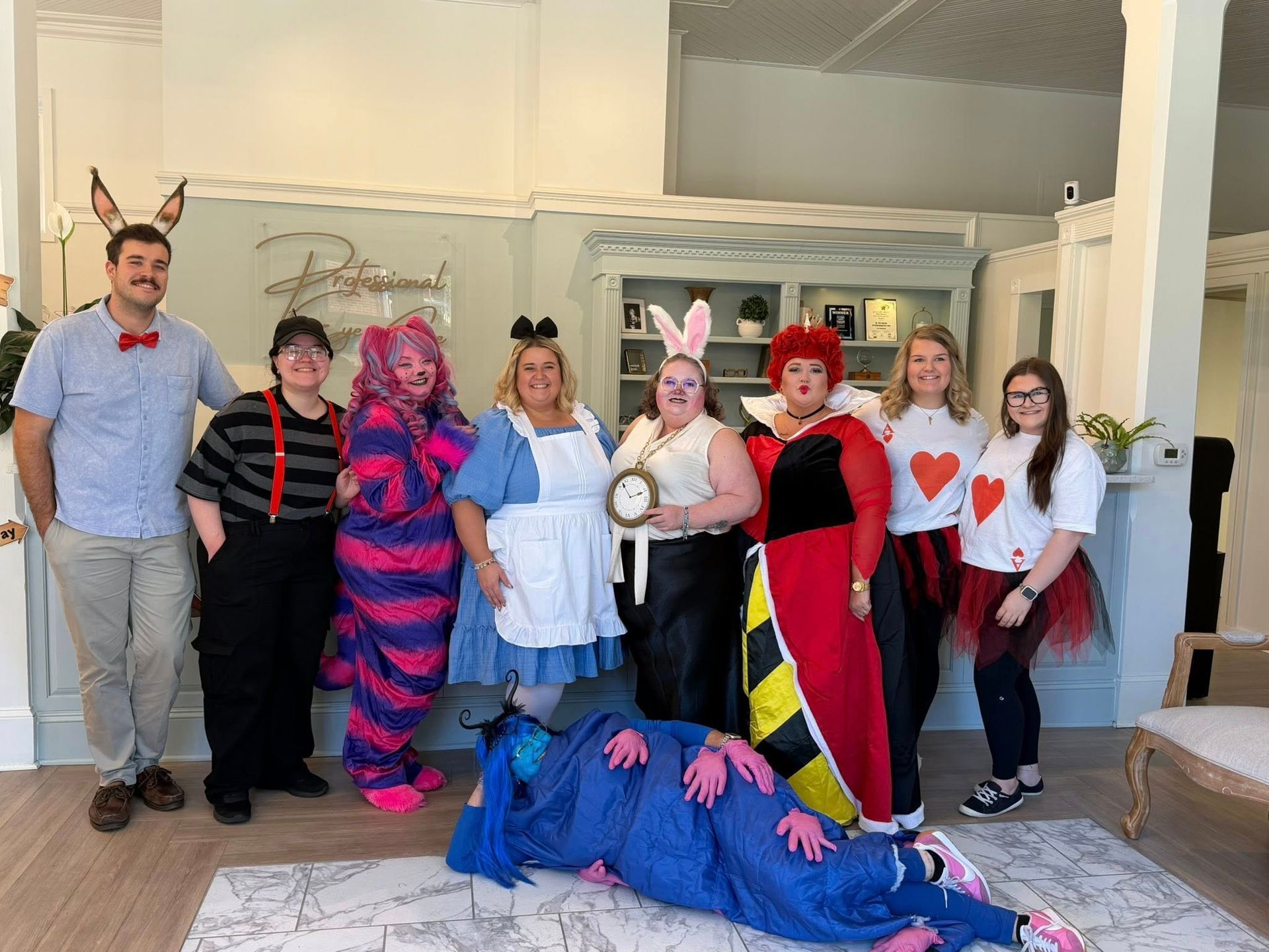 Costumed group posing indoors beside a blue dragon prop under the “Bluebird” sign in Hope Mills, NC.