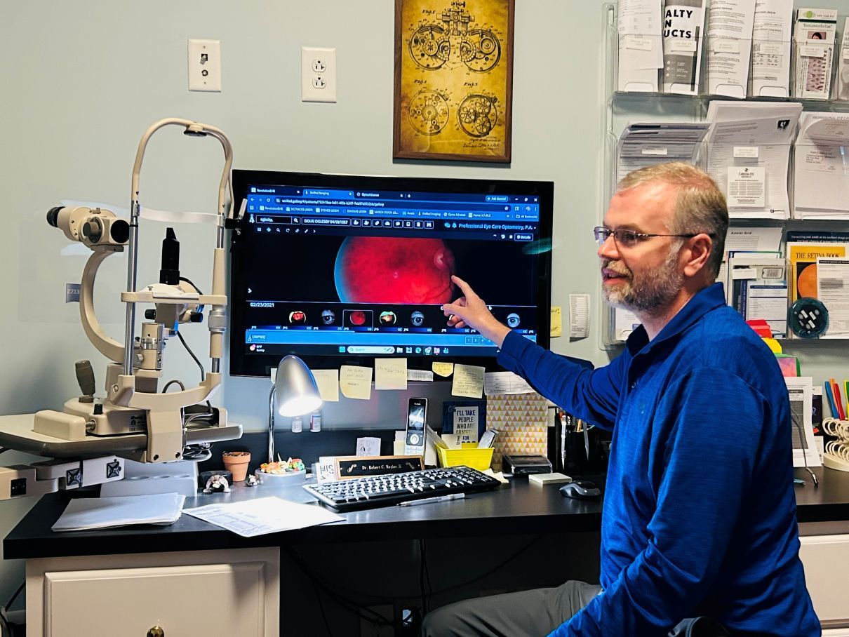 Scientist in a lab points at a microscope image on a computer monitor in Hope Mills, NC.